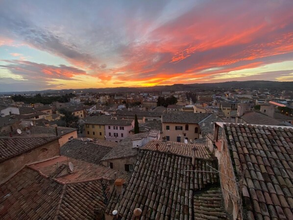 A cityscape with traditional architecture and a sunset sky.