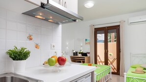 A modern kitchen with a dishwasher, a sink, and a fruit bowl on the counter. - Naxos Diamond Studios Apartments (Naxos)