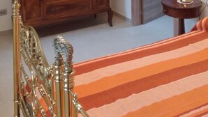 Ein Schlafzimmer mit einem Bett, einem Schminktisch, einem Spiegel und einer Klimaanlage.