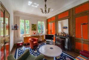 Télévision, cheminée, lecteur de DVD, livres