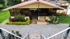 A reception area with a sign, a bench, and a garden. - Hospederia El Portal de las Flores (Chia)