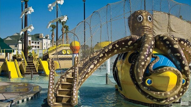 An octopus-themed water play area with slides and a netted enclosure.
