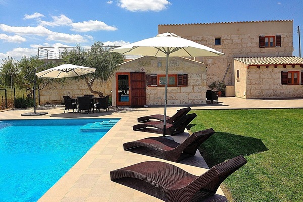 Bild vom Haus mit Schwimmbad und Sonnenliegen auf der Liegewiese