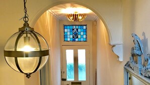 A hallway with a white door, a stained glass window, and a decorative metal sculpture. - The Walton House near City Center (Oxford)
