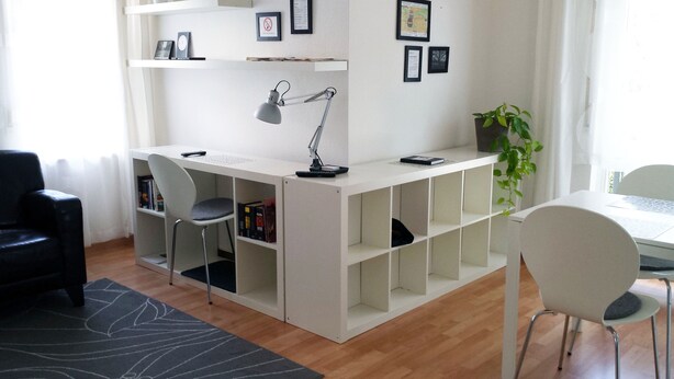 A modern, well-lit room with a white desk, two chairs, a desk lamp, and a bookshelf. - FeWo II, V und VI  - Altstadt - Am grossen Garten (Dresden)