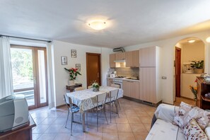 Un espace de vie compact comprenant un coin repas, une kitchenette et un canapé.