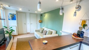 Une cuisine moderne dotée d’un îlot central, de meubles blancs et d’un coin repas avec une banquette.