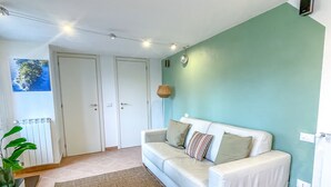 Un salon avec un canapé blanc, un tapis marron et une table basse en bois.