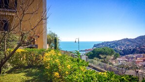 Une vue sur la côte, avec un bâtiment, de la végétation et un ciel dégagé.