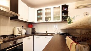 A modern kitchen with white cabinets, a stainless steel range, and a built-in oven. - Apartment with pool, air conditioning, WiFi (Krnica)