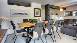 Et moderne spiseområde med et træbord og grå polstrede stole.