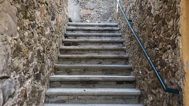 A narrow stone staircase with metal handrails, leading upwards through a confined space with rough walls. - OliLer s House&Garden Zona Centro (Guanajuato)