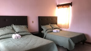 Two twin beds with green bedding, a dark headboard, and a nightstand between them. - OliLer s House&Garden Zona Centro (Guanajuato)