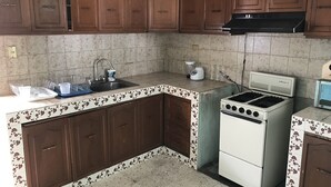 A kitchen with brown cabinets, a white stove, and a sink. - OliLer s House&Garden Zona Centro (Guanajuato)