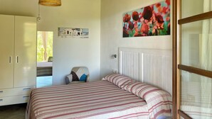 Quarto com cama, janela, radiador, pintura e ventoinha de teto.
