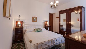 A bedroom with a bed, bedside tables, a mirror, and a chandelier. - My Rental Homes - Il Giardino di Ravello with ample private garden and sea view (Ravello)