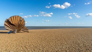 A large metallic shell sculpture on a pebbled beach with a clear blue sky. - River View, Aldeburgh (Aldeburgh)