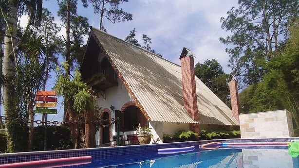 Un área de piscina con un edificio de techo inclinado y chimeneas de ladrillo.
