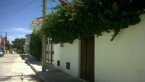 A quiet street with a white building, a wooden door, and a small window. - Studio Kin.  Close to Beaches, diving and Island Attractions. Paradise found. (Cozumel)