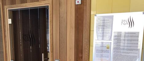A wooden door with a glass panel and a sign that reads "SAUNA".