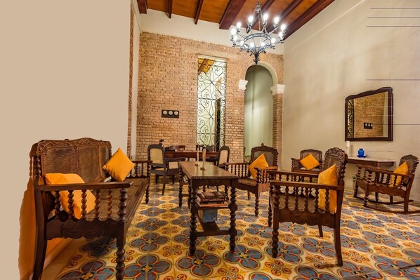 Un comedor con muebles de madera, piso estampado y pared de ladrillo.