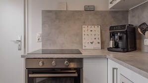 Une cuisine moderne équipée d’un four encastré, d’une machine à café et d’une pancarte de bienvenue.