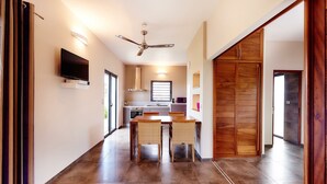 Une cuisine moderne avec un coin repas, des armoires en bois et un ventilateur de plafond.