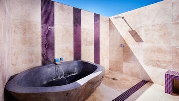 Une salle de bain moderne avec une baignoire sur pieds, des murs carrelés et un espace douche.