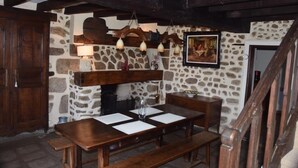 Un interior rústico con pared de piedra, muebles de madera y chimenea.