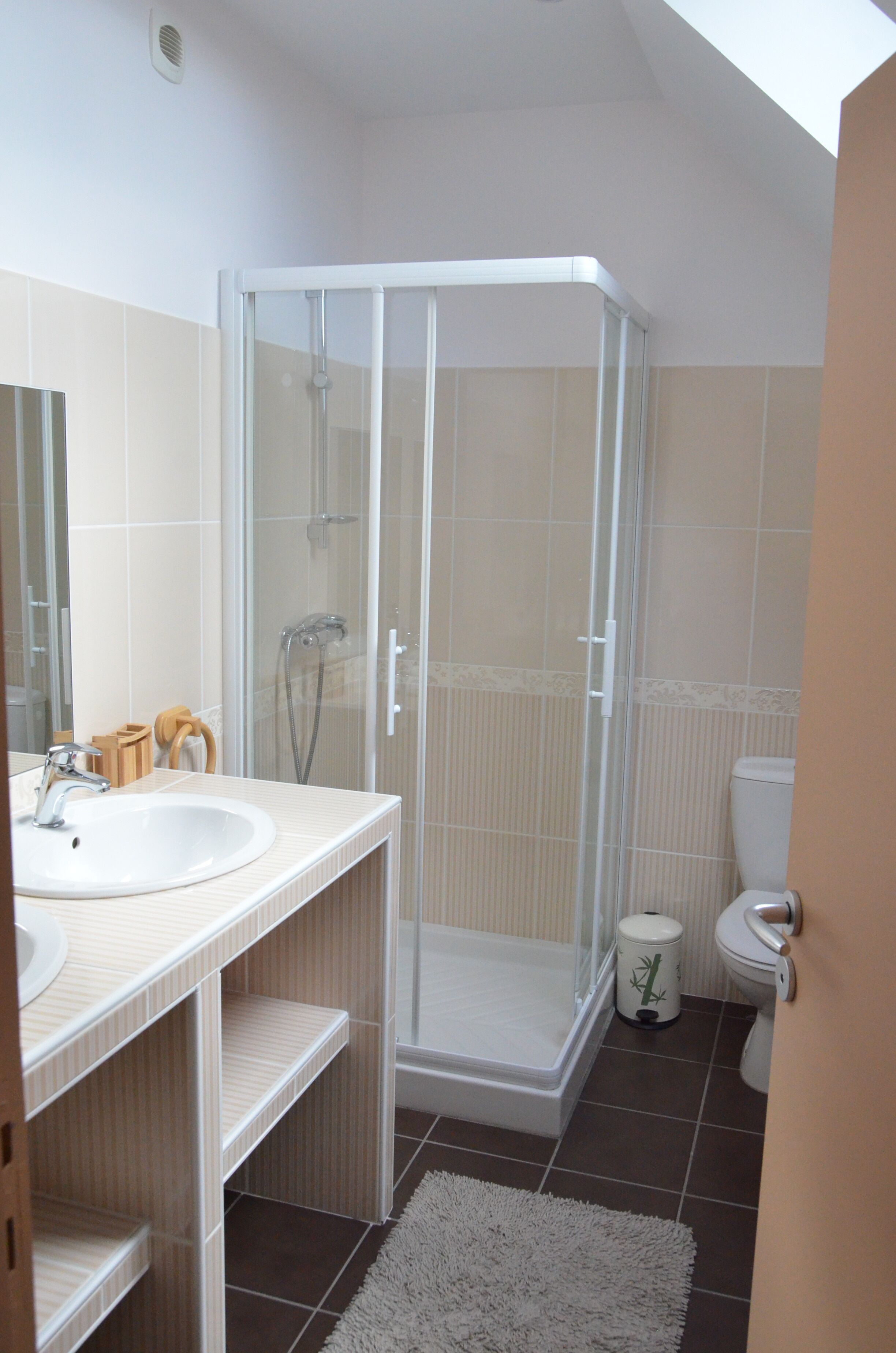 Une salle de bain moderne avec une douche à parois de verre, un lavabo et des toilettes.