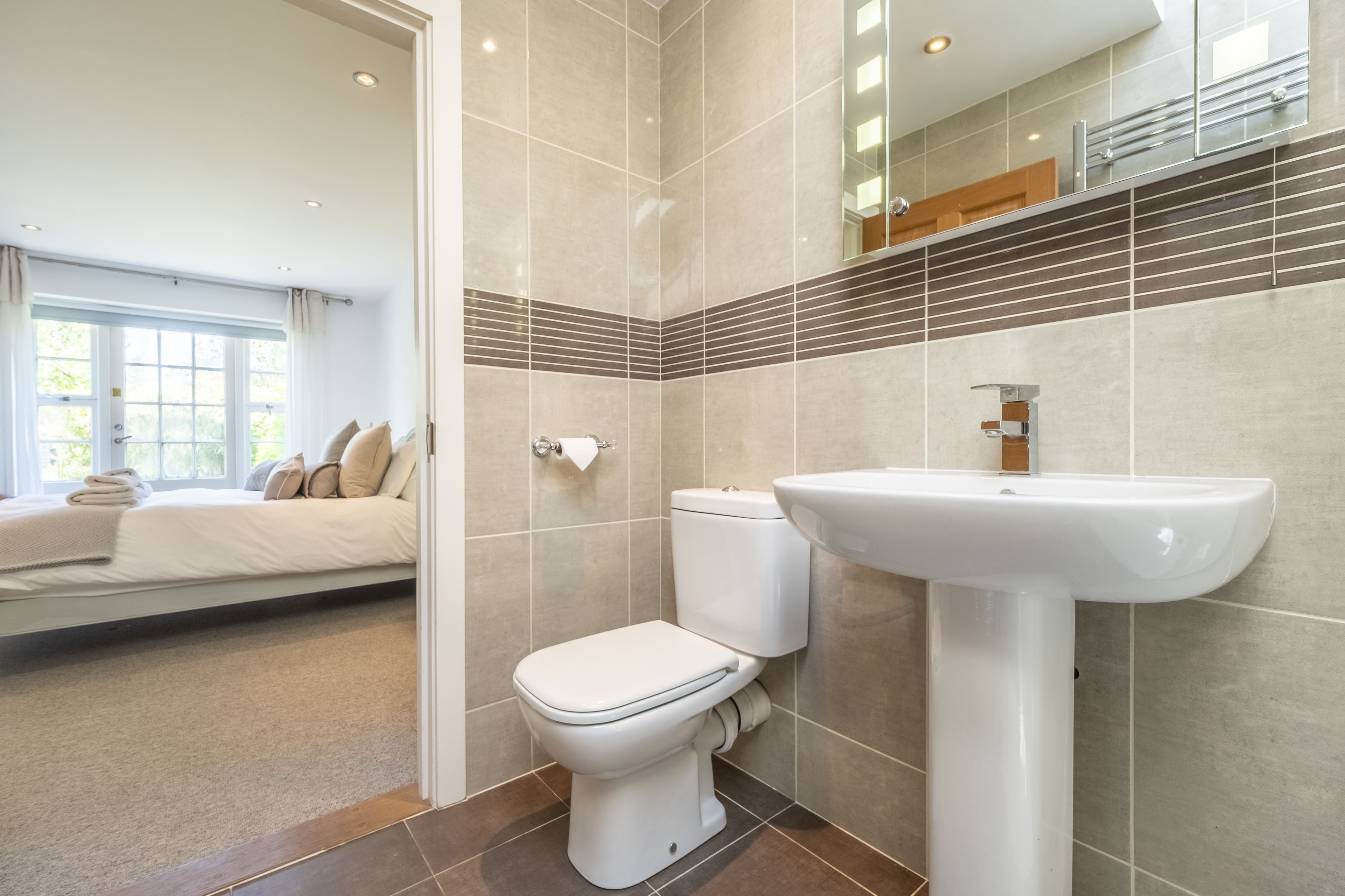 Une salle de bain moderne avec des toilettes, un lavabo et un grand miroir.