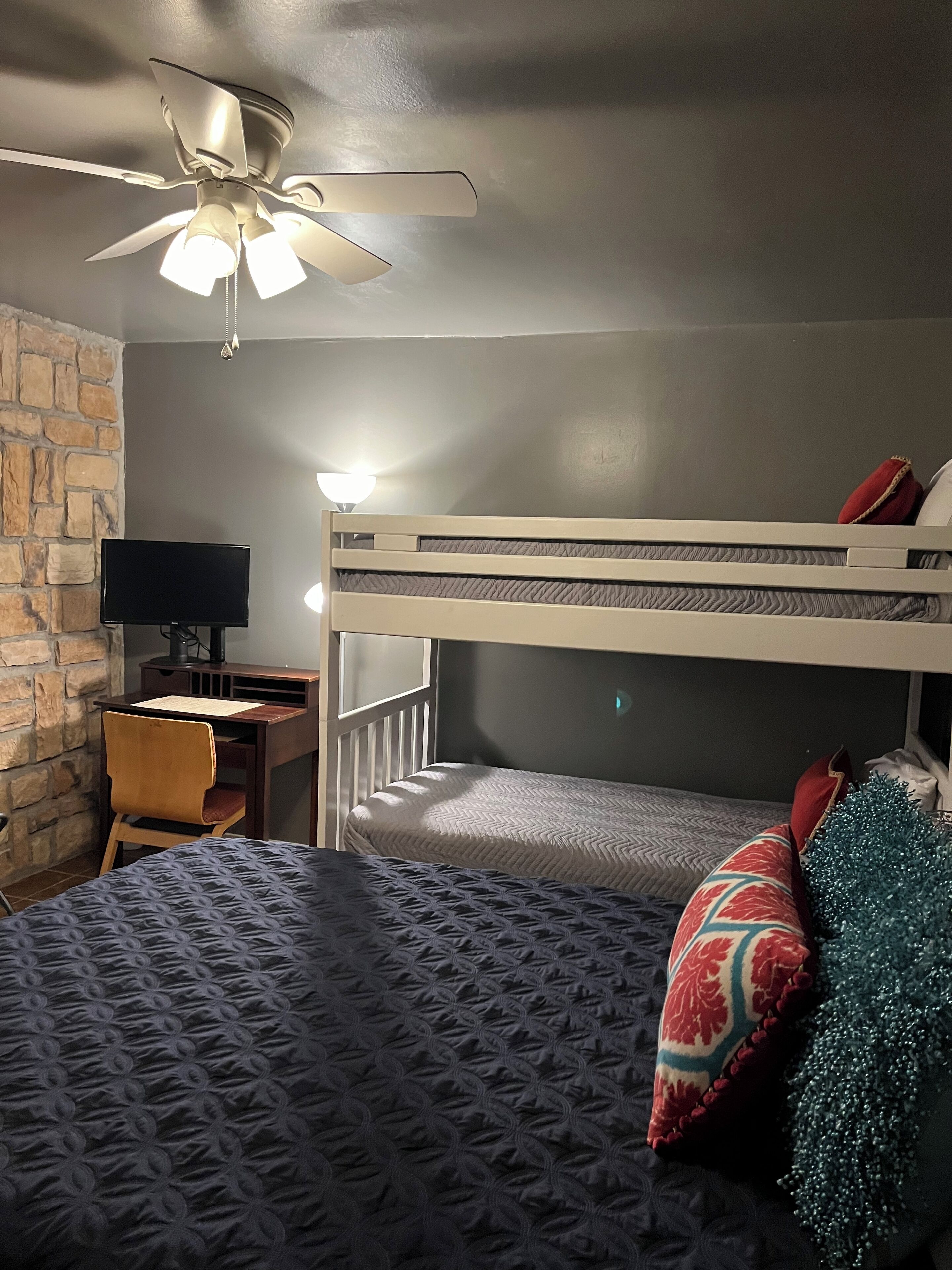 Bedroom 2 with queen bed, bunk beds and desk with monitor and docking station.