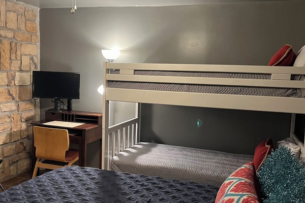 Bedroom 2 with queen bed, bunk beds and desk with monitor and docking station.