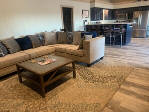 Una sala de estar con un sofá modular, una mesa de centro y un tapete estampado.