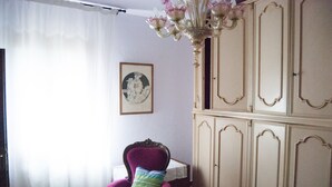 A room with a chair, a cabinet, and a chandelier. - Isolated and peaceful farm located on the slopes of an enchanting valley (Riparbella)
