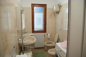 Een douche, een haardroger, een bidet, handdoeken