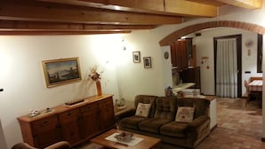 A cozy living room with a sofa set, a wooden cabinet, and a dining area with a table and chairs. - The house in Old Railway 2 (the places of the Great War) (Velo D'astico)
