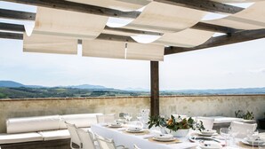An outdoor dining area with a view of rolling hills. - Medioevo&Design, Historical Umbria Tower With Private Pool, gardens, parkings (Todi)