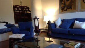 A living room with a blue sofa, a glass coffee table, and a lamp. - Casanatura Capo Mulini, traditional Sicilian rustic surrounded by nature (Acireale CT)