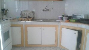Una cocina con armarios blancos, un fregadero y una estufa.