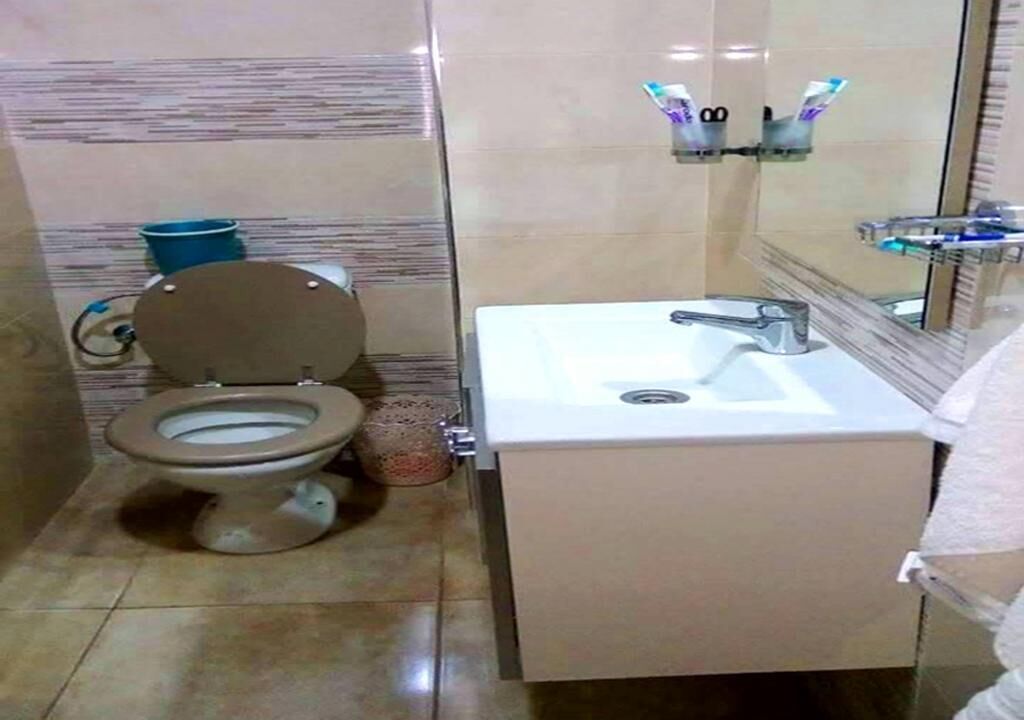 Ein Badezimmer mit Toilette, Waschbecken und Spiegel.