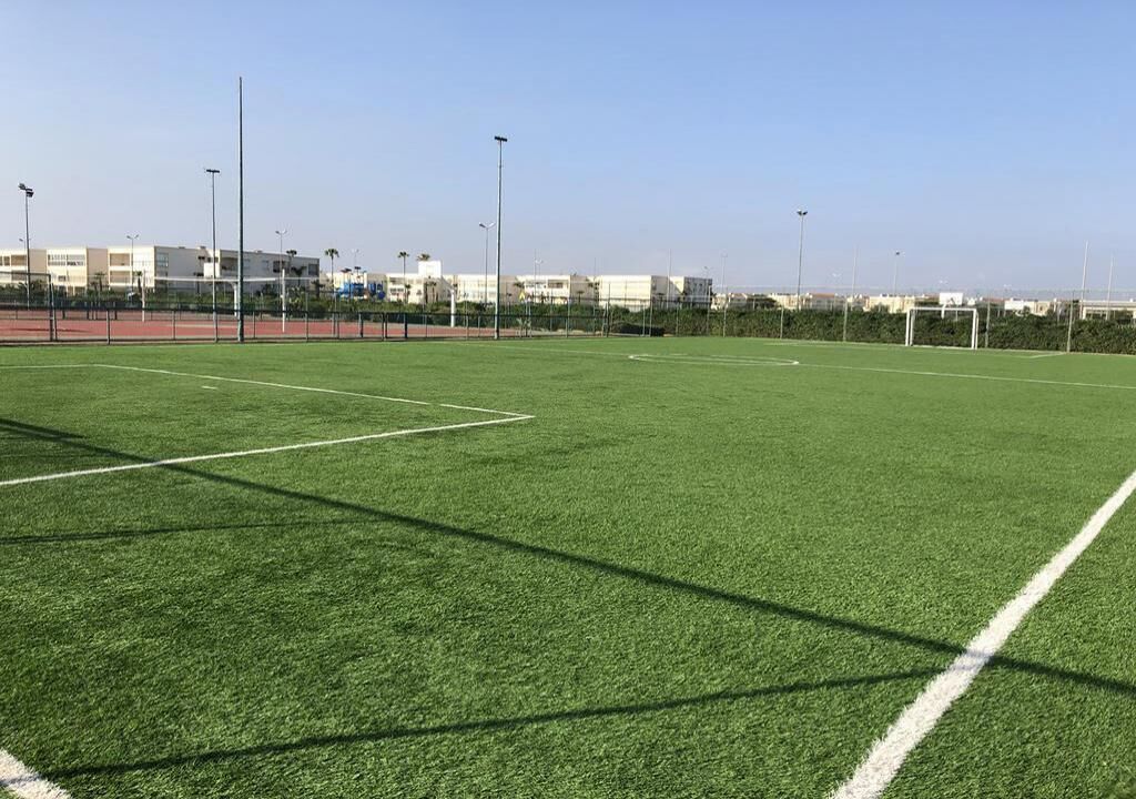 Un terrain de sport avec des poteaux de but et un ciel dégagé.