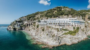 A coastal villa with multiple levels, a prominent staircase, and a view of the sea. - Hotel Cetus (Cetara)