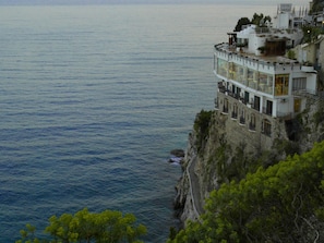 Hotel na encosta de um penhasco, com várias varandas viradas para o mar.