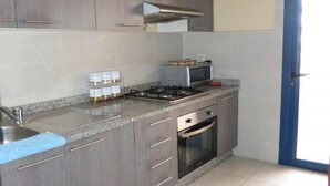 A kitchen with grey cabinets, a gas stove, a microwave, and a built-in oven.