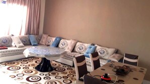 A living room with a sofa, a coffee table, and a dining table.