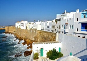 A coastal town with white buildings, a sea view, and a fortified wall. - Apartment in Assilah 4396 (Asilah)