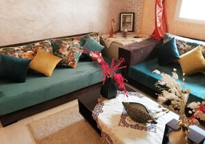 A living room with a sofa set, a coffee table with a lace tablecloth, and decorative vases. - Beautiful apartment in Marrakech 4491 (Marrakech)
