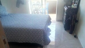 A room with a bed, a dresser, and a chair near a sliding glass door leading to an outdoor area. - Beautiful apartment in Bouznika 4475 (Bouznika)