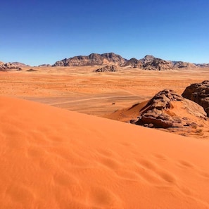 A desert landscape with sand dunes and rocky formations.